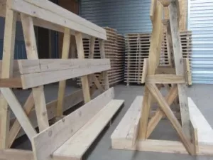 Deux chevalets en bois devant des piles de palettes dans l'entrepôt de Janès Timber