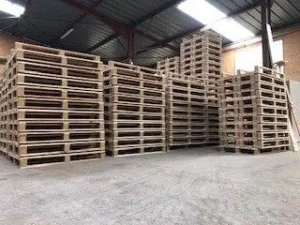 Rangées de palettes en bois empilées dans l'entrepôt de Janès Timber